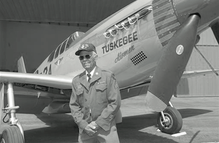 This April 7, 2011 photo by Bruce Talamon shows Clarence E. “Buddy” Huntley Jr., a member of the Tuskegee Airmen, the famed all-black squadron that flew in World War II, posing with a P-51C Mustang fighter plane similar to the one that he was a crew chief on while overseas during the war, at Torrance, Calif., Airport. (AP Photo/Bruce Talamon)